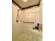 Bright shower with white tile, marble trim, hand shower head and a built-in shelf at 30442 Lettingwell Cir, Wesley Chapel, FL 33543