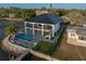 Aerial view of a waterfront property with a pool, manicured lawn, and private dock at 3310 Sunset N Dr, St Petersburg, FL 33710