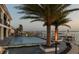 Backyard swimming pool with surrounding wood deck and a large palm tree with a beautiful waterfront view at 3310 Sunset N Dr, St Petersburg, FL 33710