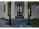 Grand home entrance with a striking arched doorway and elegant landscaping at 3310 Sunset N Dr, St Petersburg, FL 33710