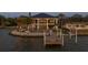 An exclusive waterfront home presents lush landscaping, a private dock, and a stunning two-story facade at 3310 Sunset N Dr, St Petersburg, FL 33710