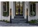 Grand entrance featuring a modern black door, elegant steps, and decorative flame lanterns at 3310 Sunset N Dr, St Petersburg, FL 33710