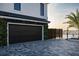 Attached two-car garage featuring lush green foliage and stylish herringbone driveway at 3310 Sunset N Dr, St Petersburg, FL 33710