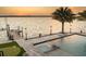 Picturesque sunset view from the waterfront pool area with a dock and palm trees at 3310 Sunset N Dr, St Petersburg, FL 33710