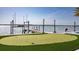 Putting green by the water with a private dock and serene bay views on a sunny day at 3310 Sunset N Dr, St Petersburg, FL 33710