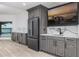 Stylish wet bar featuring gray cabinets, stone countertops, and stainless steel appliances at 3310 Sunset N Dr, St Petersburg, FL 33710