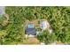 Aerial view of a home with a pool and metal workshop surrounded by lush trees at 5404 Carso Ter, North Port, FL 34286