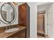 Bathroom with granite countertop, dark wood cabinets, large mirror, and walk-in shower at 5404 Carso Ter, North Port, FL 34286