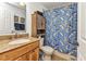 Well-lit bathroom with a granite countertop vanity, a linen closet, toilet, and a shark themed shower curtain at 5404 Carso Ter, North Port, FL 34286