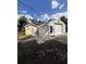 View of a small yellow home with a blue door next to a large, white garage-like structure at 5404 Carso Ter, North Port, FL 34286