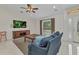 Comfortable living room featuring a ceiling fan and a large window at 5404 Carso Ter, North Port, FL 34286