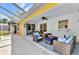 Screened patio with multiple seating areas and a ceiling fan at 5404 Carso Ter, North Port, FL 34286