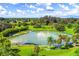 Community swimming pond with grassy area and shade trees, perfect for relaxation and Gathering fun at 5404 Carso Ter, North Port, FL 34286