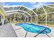 A screened in pool with blue tiled trim, and decorative dolphin accents offers a refreshing and inviting backyard oasis at 5404 Carso Ter, North Port, FL 34286