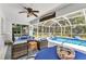 Covered outdoor living space featuring comfortable seating overlooking sparkling screened pool and lush greenery at 5404 Carso Ter, North Port, FL 34286