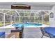 View of the screened-in pool area surrounded by lush greenery at 5404 Carso Ter, North Port, FL 34286