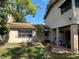Back exterior of home with mature landscaping, brick patio, and shade at 8641 May Cir, Tampa, FL 33614