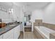 Bright bathroom featuring a soaking tub, granite countertops, and a view into the bedroom at 1238 E Kennedy Blvd # 802, Tampa, FL 33602