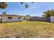 Residential backyard with a grassy area, privacy fence, and surrounding homes at 15406 2Nd E St, Madeira Beach, FL 33708
