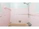 Close-up of pink tiled bathtub and shower with metal fixtures at 15406 2Nd E St, Madeira Beach, FL 33708