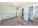 Green bedroom needing restoration, featuring closet with sliding mirror doors and ample natural light at 15406 2Nd E St, Madeira Beach, FL 33708