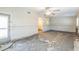 Large living room with ceiling fan, damaged tile floors, and doorway at 15406 2Nd E St, Madeira Beach, FL 33708