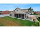 Spacious backyard featuring a patio, lush lawn, and a screened in porch at 29704 Eagle Station Dr, Wesley Chapel, FL 33543