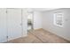 Bedroom with a small window, paneled walls, closet, and neutral carpet with a view into another room at 4100 46Th N Ave, St Petersburg, FL 33714
