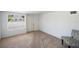 The bedroom features neutral carpeting, a large window with blinds, white walls, and a decorative chair at 4100 46Th N Ave, St Petersburg, FL 33714
