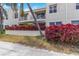 Residential building with balconies, enhanced by vibrant red foliage and lush greenery at 6131 Bahia Del Mar Blvd # 139, St Petersburg, FL 33715