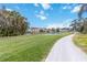 Scenic view of a golf course with lush green fairways, a pond, and palm trees under a sunny sky at 6131 Bahia Del Mar Blvd # 139, St Petersburg, FL 33715