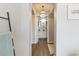 Bright hallway featuring wood floors, leading to a bathroom with white cabinets and a decorative chandelier at 6131 Bahia Del Mar Blvd # 139, St Petersburg, FL 33715