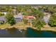 Aerial view of a lakeside property with a screened pool and solar panels on the terracotta roof at 8202 Shadow Pine Way, Sarasota, FL 34238
