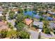 A neighborhood with a pond is surrounded by houses and lush green trees from above at 8202 Shadow Pine Way, Sarasota, FL 34238