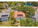 An aerial view of a backyard swimming pool, orange tile roof with solar panels, and lake view at 8202 Shadow Pine Way, Sarasota, FL 34238