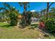 Lush backyard with tropical foliage and a screened-in pool area offering a private retreat at 8202 Shadow Pine Way, Sarasota, FL 34238