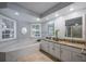 This bathroom features a double sink with granite countertops and a soaking tub for relaxation at 8202 Shadow Pine Way, Sarasota, FL 34238