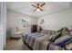 A comfortably decorated bedroom with a ceiling fan, side chair, and bright window at 8202 Shadow Pine Way, Sarasota, FL 34238