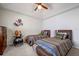 A cozy bedroom featuring two twin beds, a ceiling fan, and football-themed decor at 8202 Shadow Pine Way, Sarasota, FL 34238