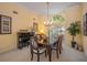 Formal dining room with a grand piano, chandelier, and large window for natural light at 8202 Shadow Pine Way, Sarasota, FL 34238