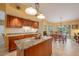 Charming kitchen with a granite countertop island and wooden cabinets at 8202 Shadow Pine Way, Sarasota, FL 34238