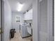 A well-lit laundry room featuring a washer, dryer, utility sink and built-in cabinets at 8202 Shadow Pine Way, Sarasota, FL 34238