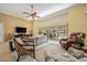 Bright living room features comfortable seating, a ceiling fan and a view of the pool area at 8202 Shadow Pine Way, Sarasota, FL 34238