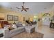 Cozy living room featuring a plush sectional, ceiling fan, and an open floor plan at 8202 Shadow Pine Way, Sarasota, FL 34238
