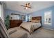 Comfortable main bedroom with soft blue walls, featuring a dresser and natural light from window at 8202 Shadow Pine Way, Sarasota, FL 34238