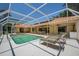 Screened pool with lounge chairs, connecting seamlessly to the home's interior at 8202 Shadow Pine Way, Sarasota, FL 34238