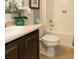 Clean bathroom featuring white fixtures, dark wood vanity, ceramic tile floors, and a shower with a white tile surround at 6179 Notre Dame Ter, North Port, FL 34291