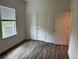 Bright bedroom featuring wood-look flooring, a window, and double closets for ample storage at 6179 Notre Dame Ter, North Port, FL 34291