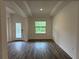 Inviting entryway with decorative glass door, tray ceiling, and sleek, dark wood flooring at 6179 Notre Dame Ter, North Port, FL 34291