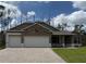 Charming home showcasing a stone facade, a three-car garage, and a beautifully paved driveway at 6179 Notre Dame Ter, North Port, FL 34291